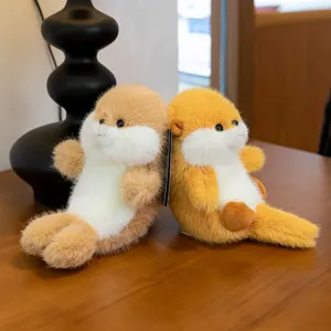 Two cute puffed penguin plush toys sitting together on a wooden desk next to a black lamp