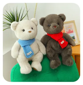 Pareja de ositos de peluche con bufandas de punto coloridas en una silla verde