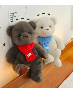 Dos ositos de peluche con bufandas de punto rojas y azules en un cabecero de cama de madera