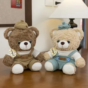 Pair of adorable teddy bear plush toys wearing corduroy overalls and painter hats