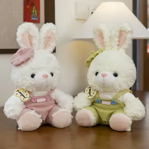 Two adorable plush rabbits wearing pink and green corduroy overalls and matching berets