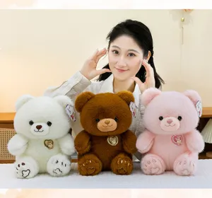 Drie schattige teddybeer knuffels in wit, bruin en roze gepresenteerd door een model.