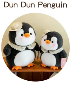 Zwei süße Pinguin-Stofftiere mit kleinen Strohhüten und floralen Spitzenkragen im Regal