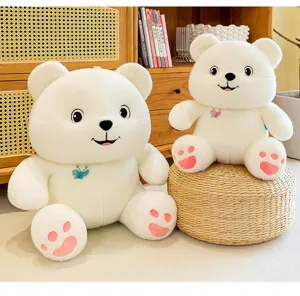 Close-up detail of cute white butterfly bear plush toys with embroidered pink paw prints