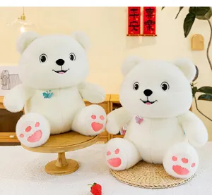 Close-up of two white plush teddy bears with butterfly sequin details in a cozy room