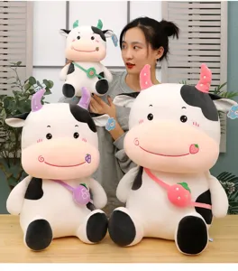 Close-up view of cute cartoon plush cow toys featuring fruit bags and colorful horns decoration