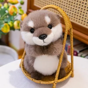 Adorable peluche de nutria realista en postura de oración dentro de una cesta tejida
