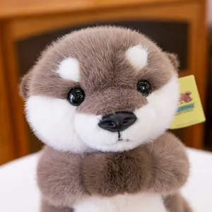 Lindo peluche de nutria rezando con suave pelaje marrón y blanco, muñeco de peluche