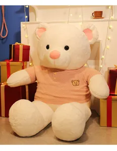 Detailed view of a large white teddy bear plush toy wearing a pink knitted sweater