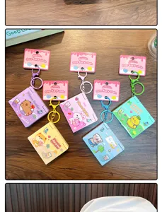 Detail showing a variety of cute cartoon folding mirror keychains functioning as phone stands
