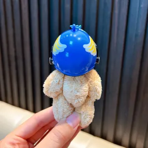 Plush bear keychain wearing a blue miniature football helmet with wing patterns