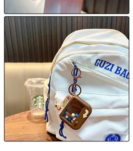 Mini-Greifautomat Schlüsselanhänger braun an einem weißen Rucksack Detailansicht