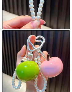 Detail van de glanzende appelbedels aan een parelmoer kralen sleutelhanger tasaccessoire