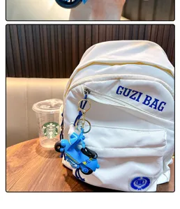 Detailed view of a creative blue motorcycle keychain pendant on a white backpack