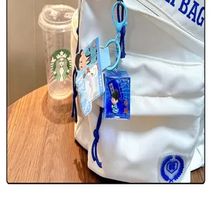 Porte-clés liquide bleu avec figurine de dessin animé sur un sac à dos blanc