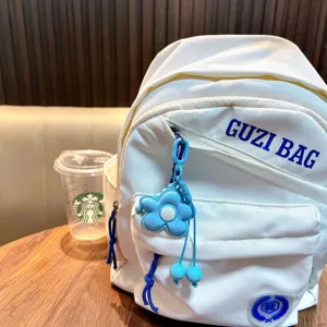 Colgante de flor para bolso en aleación azul con cordón trenzado en una mochila