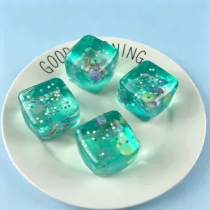 Nahaufnahme von durchscheinenden Eiswürfel-Squishies mit Muscheln und Sternen