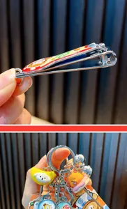 Detail of cartoon hamburger nail clipper and animal keychain charms with bells.