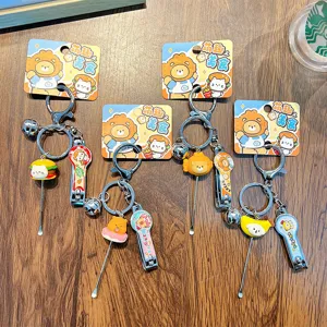 Cartoon food themed nail clipper keychain set with ear pick on wooden background