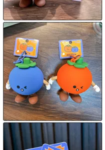 Close-up of cute fruit-shaped silicone coin purses in blue and orange with keychains