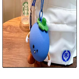 Detail view of a cute blue silicone mangosteen character pendant on a white bag