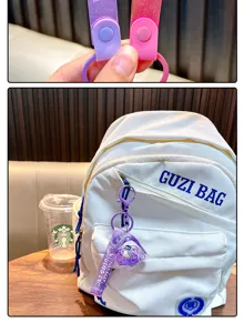 Detail of purple oil-filled fish keychain with penguin and liquid glitter on a white bag
