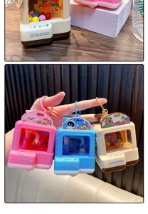 Nahaufnahme von leuchtenden Mini-Greifautomat-Schlüsselanhängern in Pink Blau und Creme