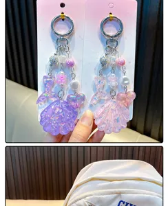 Detailed view of purple and pink glitter shell and fish tail acrylic keychains
