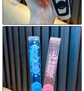 Detailopname van glitter PVC-sleutelhangerbandjes met 'Daydream' en 'Just Keep Doing It' tekst