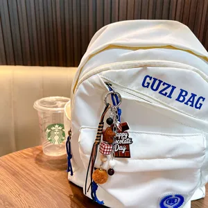 Porte-clés mignon thème chocolat avec pompon sur un sac à dos blanc