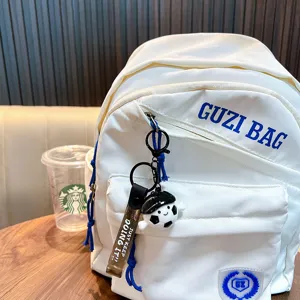 Schattige voetbaljongen PVC-sleutelhanger aan een witte rugzak voor sportfans
