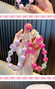 Close-up of colorful beaded phone charms with bows and faceted crystal-like beads