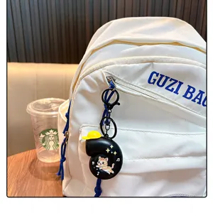 Cute black musical snail keychain charm on a white backpack