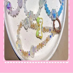 Detalle en primer plano de un colgante para móvil con cuentas de cristal y lazo de acrílico