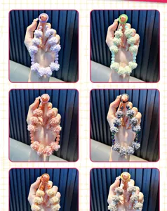 Vue détaillée de dragonnes de téléphone en pompons et perles aux styles variés.