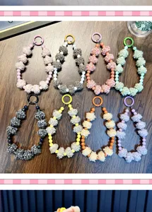 Détail de lanières de téléphone en perles et pompons de couleurs variées.