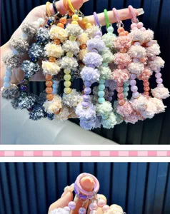 Vue détaillée d'un charm de téléphone avec pompons en peluche colorés et perles brillantes