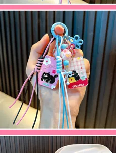 Close-up of a cartoon black cat keychain with colorful braided ropes and flower charm