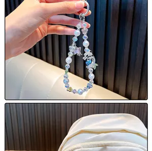 Vue détaillée des perles de cristal irisées et du pendentif panda sur une lanière