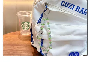 Gros plan d'un porte-clés en perles de cristal colorées avec breloque panda sur un sac.