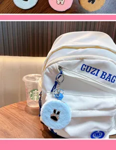 Nahaufnahme eines niedlichen blauen Plüsch-Hasenspiegel-Schlüsselanhängers an einem Rucksack.
