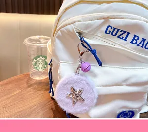 Lila Plüsch-Stern-Spiegel-Schlüsselanhänger, Taschenanhänger an einem weißen Rucksack