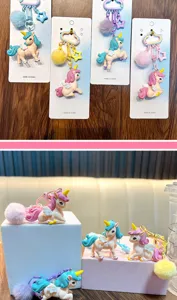 Vista detallada de lindos llaveros de unicornio con pompones suaves y tonos de pastel.