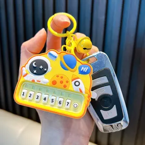 Playful yellow astronaut toy piano keychain featuring numbered buttons and a matching bell