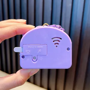 Back view of purple astronaut toy piano keychain with battery compartment