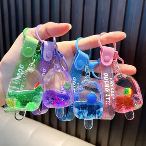 Vibrant popsicle-shaped liquid quicksand keychains with fruit charms and inspirational straps.
