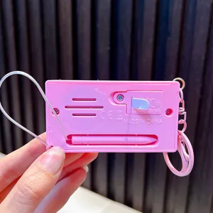 Back view of a pink mini handheld electronic piano keychain with stylus and battery door