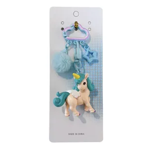Llavero de unicornio lindo con bola de pelo azul y colgante de estrella en cartón