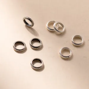 Detailed macro view of S925 sterling silver distressed wheel-shaped spacer beads for jewelry
