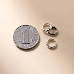 Detailed view of S925 silver retro wheel spacers next to a coin for size reference